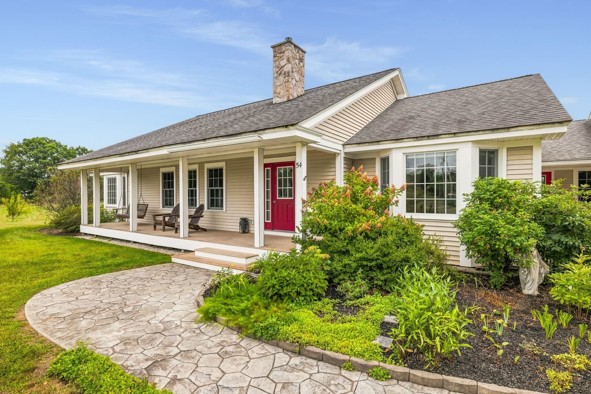 The curved paver walk through the front gardens to the porch and the red front door