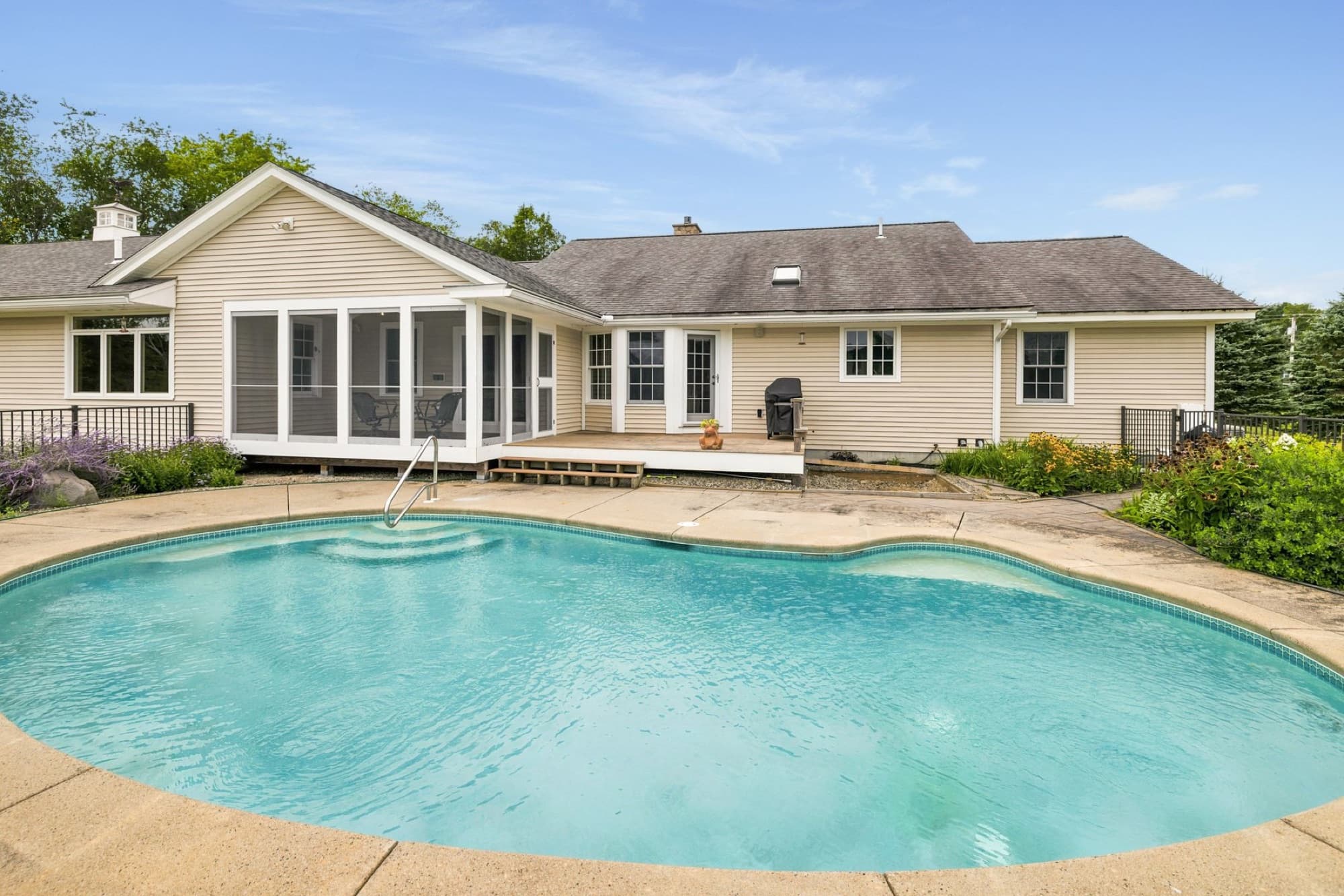 The Gunite pool with the house, the screened porch, and the deck behind it