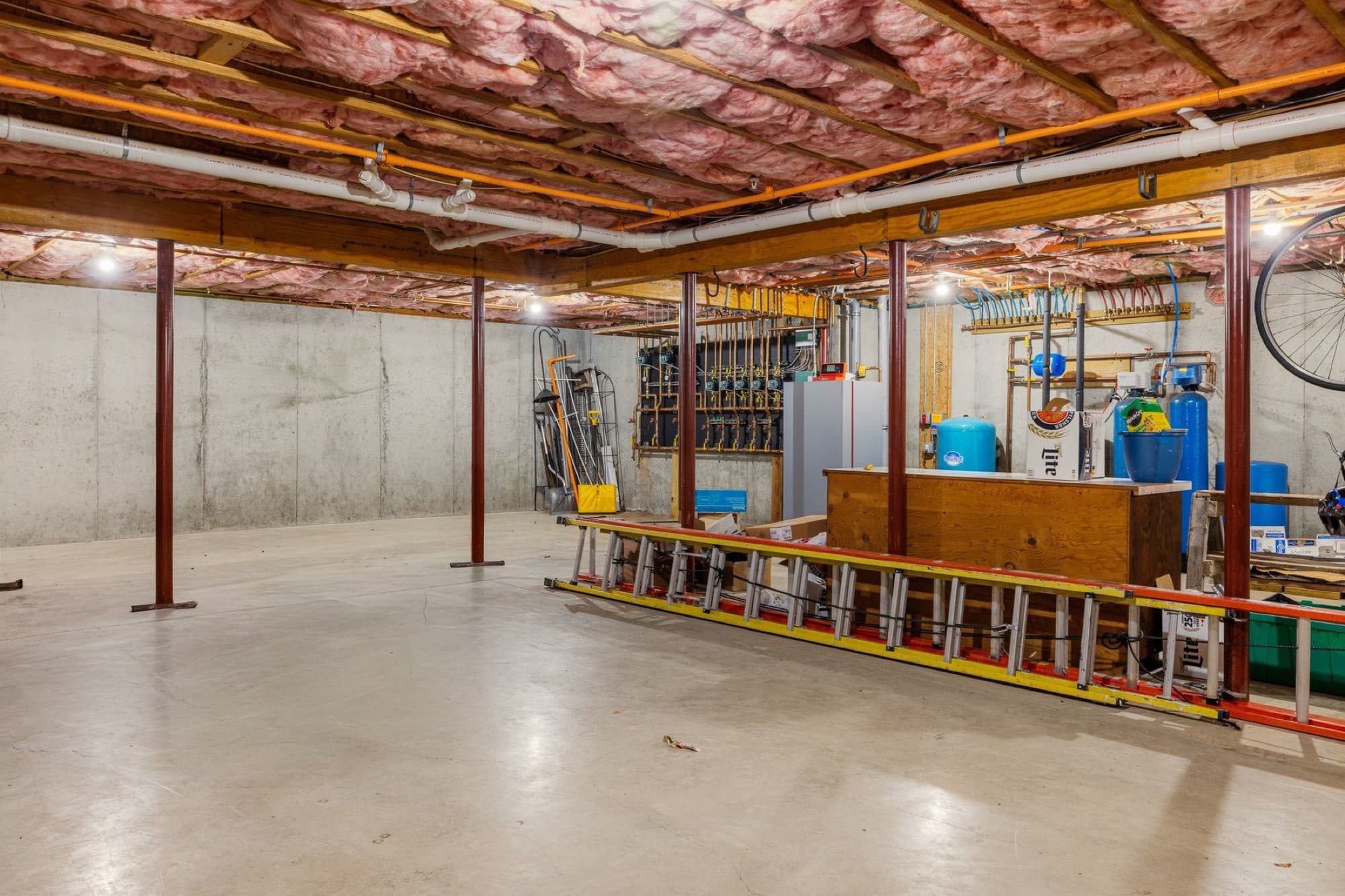 The full unfinished basement with a poured concrete floor